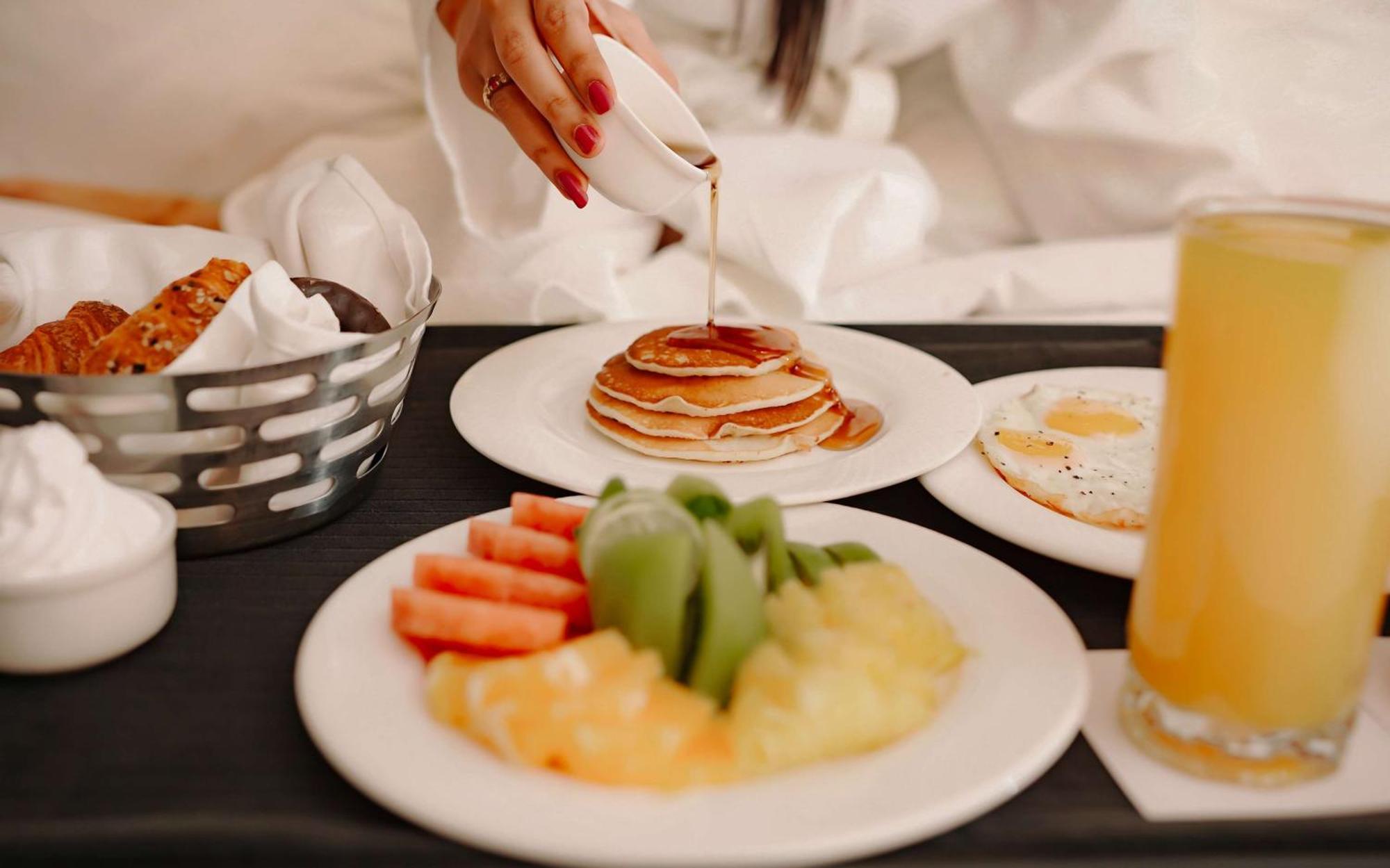 ラディソン ブル ホテル アムリトサル エクステリア 写真 A woman pouring maple syrup on a stack of pancakes